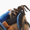 A spider crawling into the top of a boot.