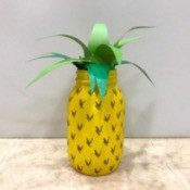 A jar that has been painted to look like a pineapple.