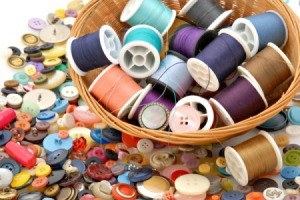 A basket of thread on a background of buttons.
