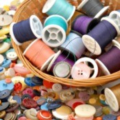 A basket of thread on a background of buttons.
