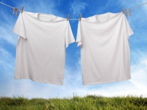 A sagging clothesline with two white t-shirts pinned on it.