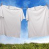 A sagging clothesline with two white t-shirts pinned on it.