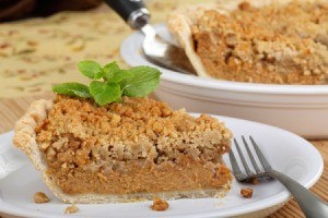 A slice of pumpkin pie with streusel topping.