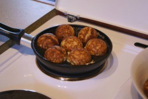 A Danish aebleskiver pan on a stove.