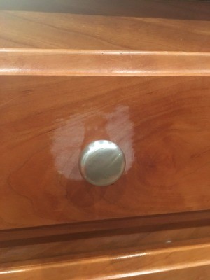 Damage caused by Murphy's Oil Soap on a wooden cabinet.