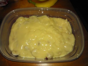 pudding on top of bananas and wafers in containers