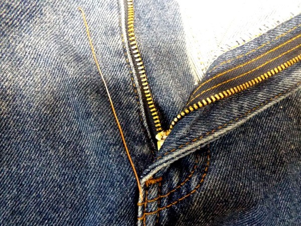 A pair of jeans with an open fly zipper.