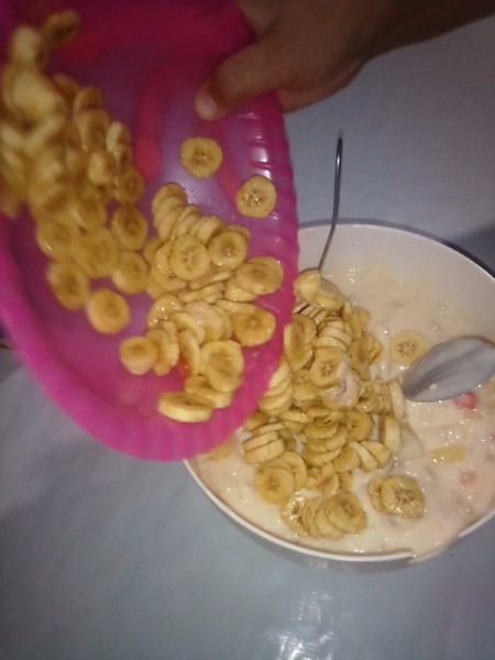 adding banana slices to bowl