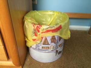 A popcorn tin being used as a trash can.