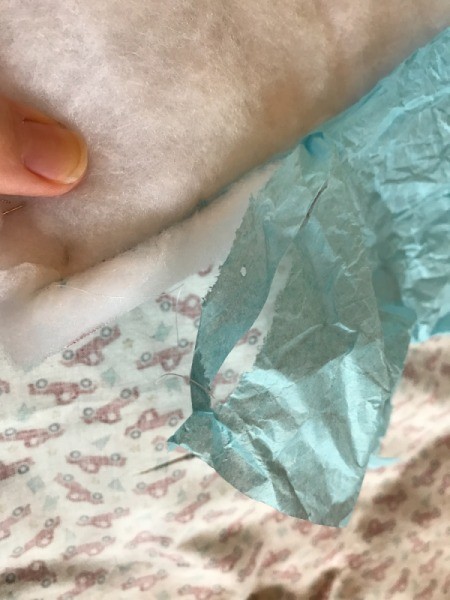 Whole Cloth Tied Quilt with Ric Rac Trim - removing tissue paper from seam