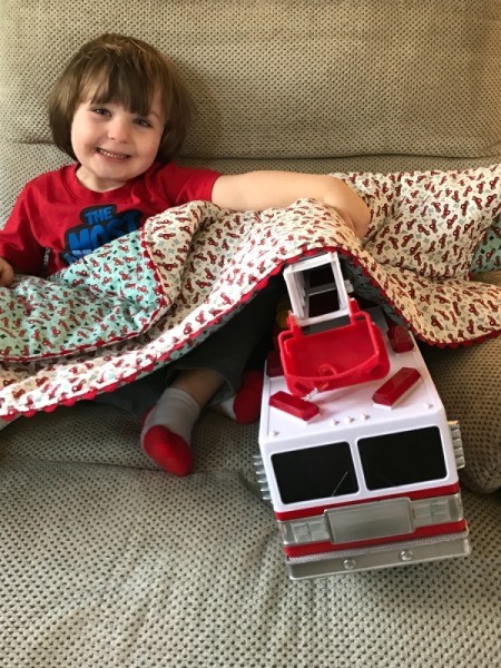 Whole Cloth Tied Quilt with Ric Rac Trim - toddle with large firetruck under the quilt