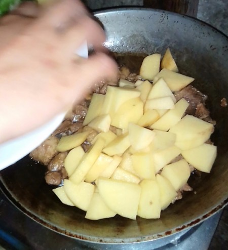 adding potatoes to beef
