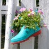 Shoe planter attached to a fence.