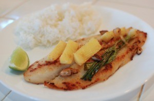 Pan Fried Tilapia with green onion and ginger chunks on plate