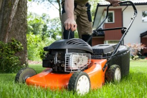 A man pulling the starter cord for a lawn mower.