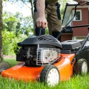 A man pulling the starter cord for a lawn mower.