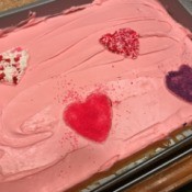 Sprinkle Hearts on a Cake - cake with heart decorations on pink frosting