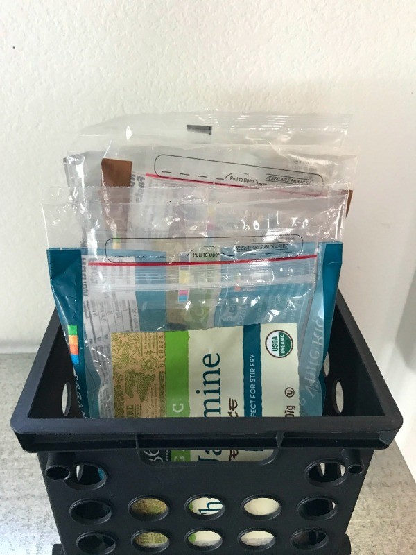 Pantry supplies organized in a plastic crate.