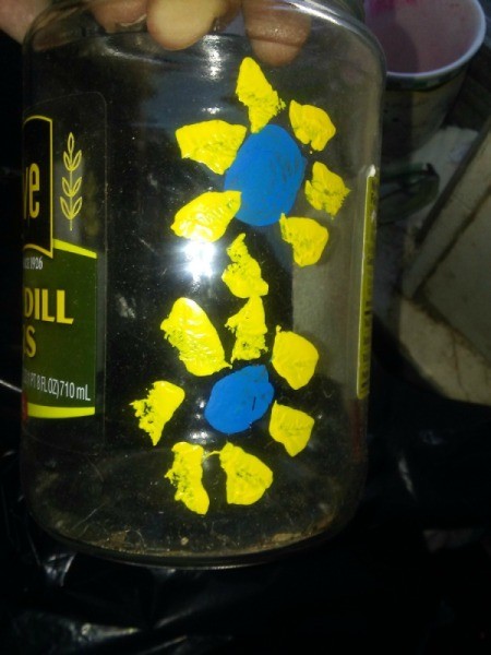 A painted container with yellow flowers.