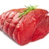 An uncooked beef roast with a sprig of rosemary on top.