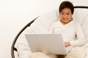 A woman sitting in a papasan style chair.