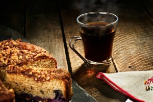 A plate of coffee cake with a cup of coffee on a table.