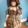 Identifying Porcelain Dolls - doll in brown plaid dress with hat