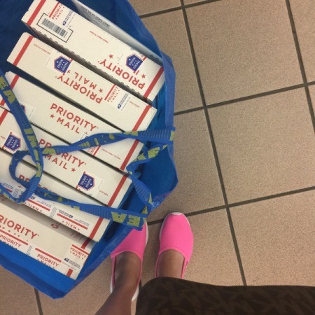 A large shopping bag full of mail packages.