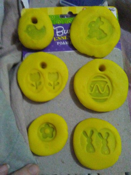 Play-Doh Stamping Activity for Children - circles of yellow Doh with various stamped images and some with holes to hang