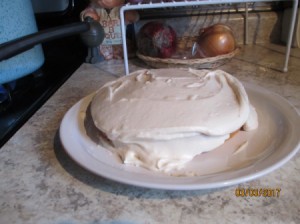 A homemade cake with frosting on a plate.
