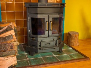 A wood stove with blackened windows.