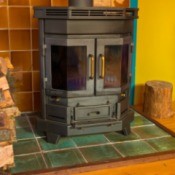 A wood stove with blackened windows.