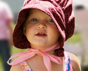 A little girl wearing a pioneer bonnet.
