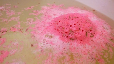 A soft bath bomb dissolving in the bathwater.