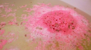 A soft bath bomb dissolving in the bathwater.