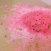 A soft bath bomb dissolving in the bathwater.