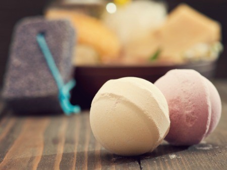 A pair of bath bombs in front of other toiletries.