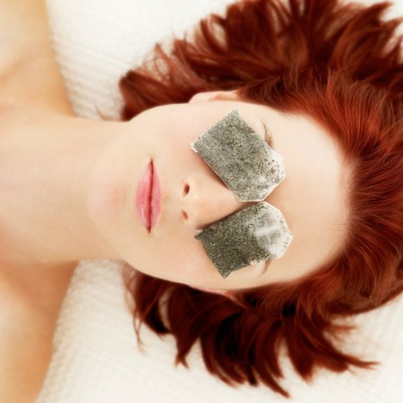 Woman with tea bags on her eyes