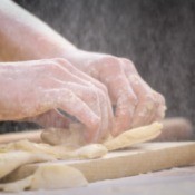 A woman making knots with dough.