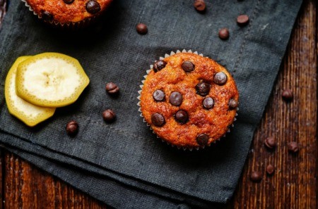 A cupcake made with bananas and chocolate chips.