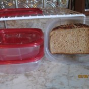 A reusable plastic container with a sandwich stored inside.