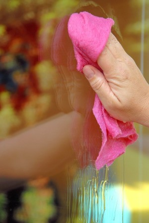 A person cleaning a window with a rag.