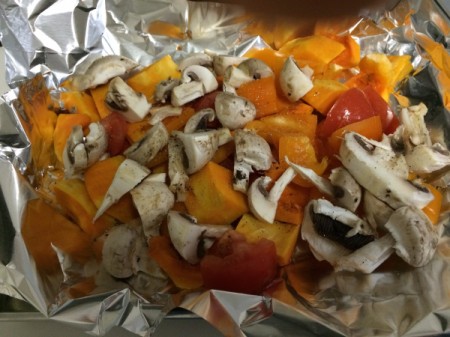 vegetables cut and laid on foil in baking pan