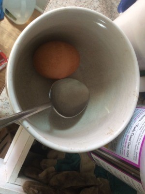 A hard boiled egg inside a cup.