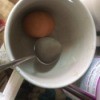 A hard boiled egg inside a cup.