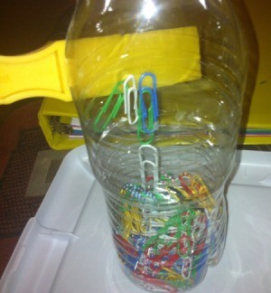 Magnetic Discovery Bottles - magnet against a bottle of paper clips
