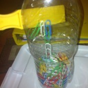 Magnetic Discovery Bottles - magnet against a bottle of paper clips