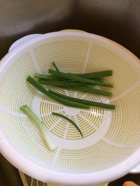 Green onions in a colander.