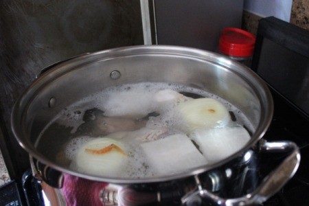 Homemade pho broth in a stockpot.