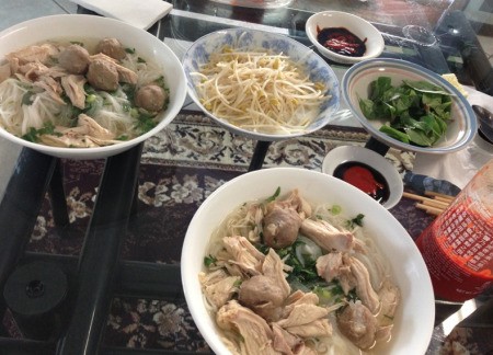 Homemade Vietnamese pho on a table, ready to eat.